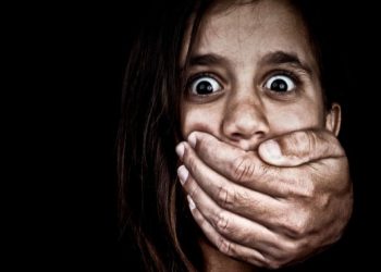 13375781 - portrait of a scared girl being abused by an adult man who covers her mouth with his hand  only his hand is visible, the rest is hidden in the shadows