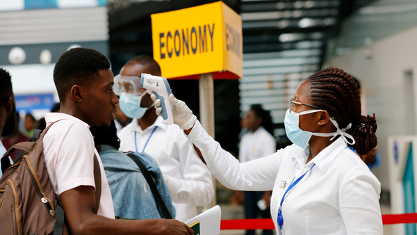 FILE PHOTO: A health worker checks the temperature of a traveller as part of the coronavirus screening procedure at the Kotoka International Airport in Accra, Ghana January 30, 2020. REUTERS/Francis Kokoroko/File Photo - RC2EUE9X5YKK