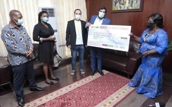 Mr. Hussein Jabir presenting the cheque to the Chief of Staff, Frema Osei Opare
