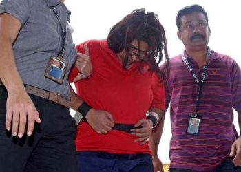 This photo provided by The Straits Times taken on August 3, 2016 and received by AFP on June 22, 2021 shows police officers escorting Gaiyathiri Murugayan (C) to her home for investigations into a case involving the starvation and death of her domestic worker in Singapore. - A Singaporean woman who starved, assaulted and ultimately killed her domestic worker was sentenced to 30 years in prison on June 22, 2021, with the judge describing the case as "among the worst types of culpable homicide". (Photo by SEAH Kwan Peng / STRAITS TIMES / AFP) / - Singapore OUT / -----EDITORS NOTE --- RESTRICTED TO EDITORIAL USE - MANDATORY CREDIT "AFP PHOTO / THE STRAITS TIMES/ SEAH KWANG PENG " - NO MARKETING - NO ADVERTISING CAMPAIGNS - DISTRIBUTED AS A SERVICE TO CLIENTS - NO ARCHIVES (Photo by SEAH KWAN PENG/STRAITS TIMES/AFP via Getty Images)