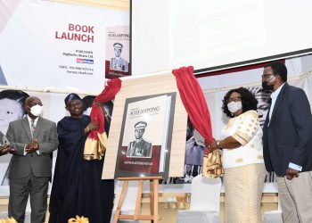 Madam Faustina Acheampong, widow and former First Lady is assisted by the special aide to His Excellency General Obasanjo to unveil the book as the Author Prof Agyeman-Duah (extreme right) looks on.