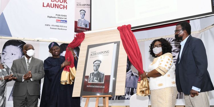 Madam Faustina Acheampong, widow and former First Lady is assisted by the special aide to His Excellency General Obasanjo to unveil the book as the Author Prof Agyeman-Duah (extreme right) looks on.