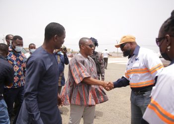 HON. MIREKU DUKER (IN SMOCK) IN A HANDSHAKE WITH DR. DANIEL MCKORLEY, CHAIRMAN, MCDAN GROUP OF COMPANIES