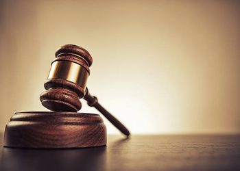 Gavel on desk. Isolated with good copy space. Dramatic lighting.