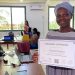 Figure 1 Ms. Kawdjoti, a former Janitor displaying her Certificate