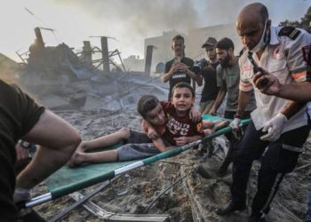 Palestinians carry wounded brothers on a stretcher in Gaza City