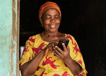 smiling elderly african woman using her phone