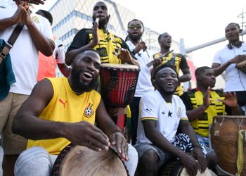 Some Ghanaian football fans drumming and dancing