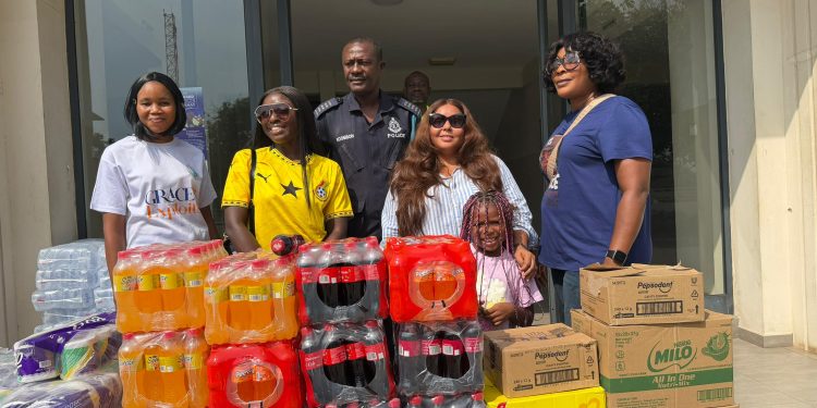 Felicity Nelson, founder of Felicity Nelson Foundation and Deputy CEO (Operations) of the Ghana Tourism Development Company, with some Prison Officers, behind a young girl.