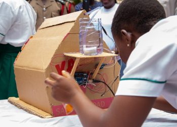 A young learner in the Telecel DigiTech Academy demonstrates how the automated fire detection prototype works at the Cohort 2 graduation ceremony in Tamale