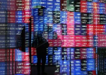 A stock quotation board is reflected on window glasses at a building in Tokyo, Japan December 11, 2025. REUTERS
