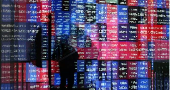 A stock quotation board is reflected on window glasses at a building in Tokyo, Japan December 11, 2025. REUTERS