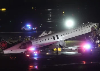 Emergency services surround the Air Canada plane damaged after crashing into a vehicle.