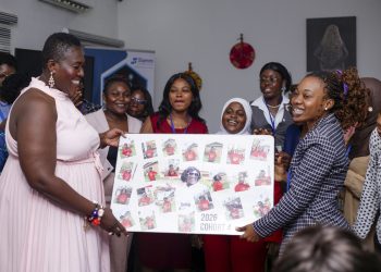 Francisca Boateng, Chief Executive Officer of Slamm Foundation, left, receiving an album of appreciation from participants in cohort 4 of Young Women in Tech programme