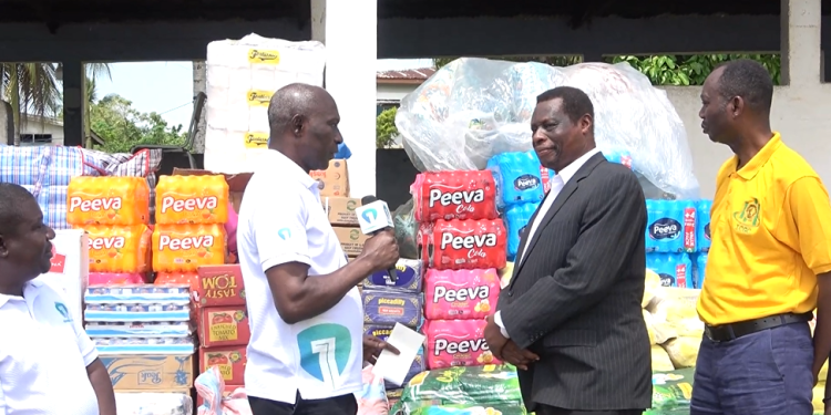 Head of Administration for Citi FM and Channel One TV, Matthew Idun (left) presenting the donation to the Founder and Director of BASCO, Reverend Victor Ofori-Amoah (right)