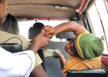 File Image of a bus conductor collecting fare from a passenger