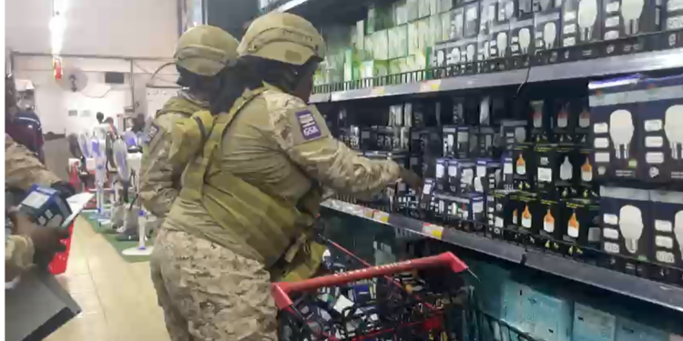GSA officials removing bulbs from shelves inside the Ashaiman China Mall warehouse.