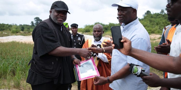 Minister for Lands and Natural Resources, Emmanuel Armah-Kofi Buah [right], handing over the documents to the Lead Operational Director of RM Ecorestore Ghana Limited, Nana Kyeame Ampratwum [left].