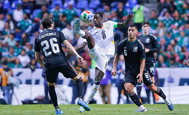 PUEBLA, MEXICO - MAY 22: Brian Gutierrez (L) and Erik Lira (R) of Mexico fight for the ball with Majeed Ashimeru (C) of Ghana during the international friendly match between Mexico and Ghana at Estadio Cuauhtemoc on May 22, 2026 in Puebla, Mexico. (Photo by Luis Cano/Jam Media/Getty Images)