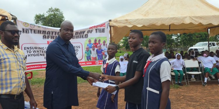 School prefect Asuo Angela, on behalf of students of Sagnarigu Girls’ Model JHS [right], presents a petition to Sagnarigu MCE Abdulai Gong [left].