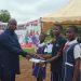 School prefect Asuo Angela, on behalf of students of Sagnarigu Girls’ Model JHS [right], presents a petition to Sagnarigu MCE Abdulai Gong [left].