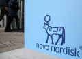People walk past a sign for Novo Nordisk’s annual general meeting at the entrance to the venue in Copenhagen, Denmark, March 26, 2026. REUTERS/Tom Little/File Photo Purchase Licensing Rights