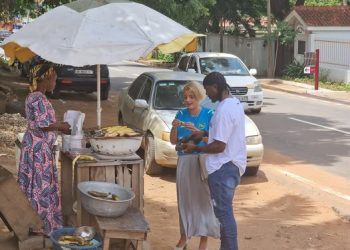 Simone Giger together with Black Star Goal Keeper, Ati Zigi buying roasted plantain in Ghana
