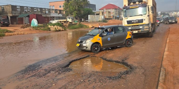 Wastewater takes over two lanes of road, while deep potholes worsen conditions